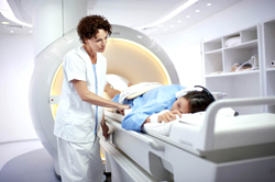 Een MR-HIFU systeem. De HIFU-transducer is ingebed in een MRI-tafel. Tijdens de behandeling worden real time MRI-beelden gemaakt om de behandeling te volgen (zie <EM>inzet</EM>). Beeld: Philips